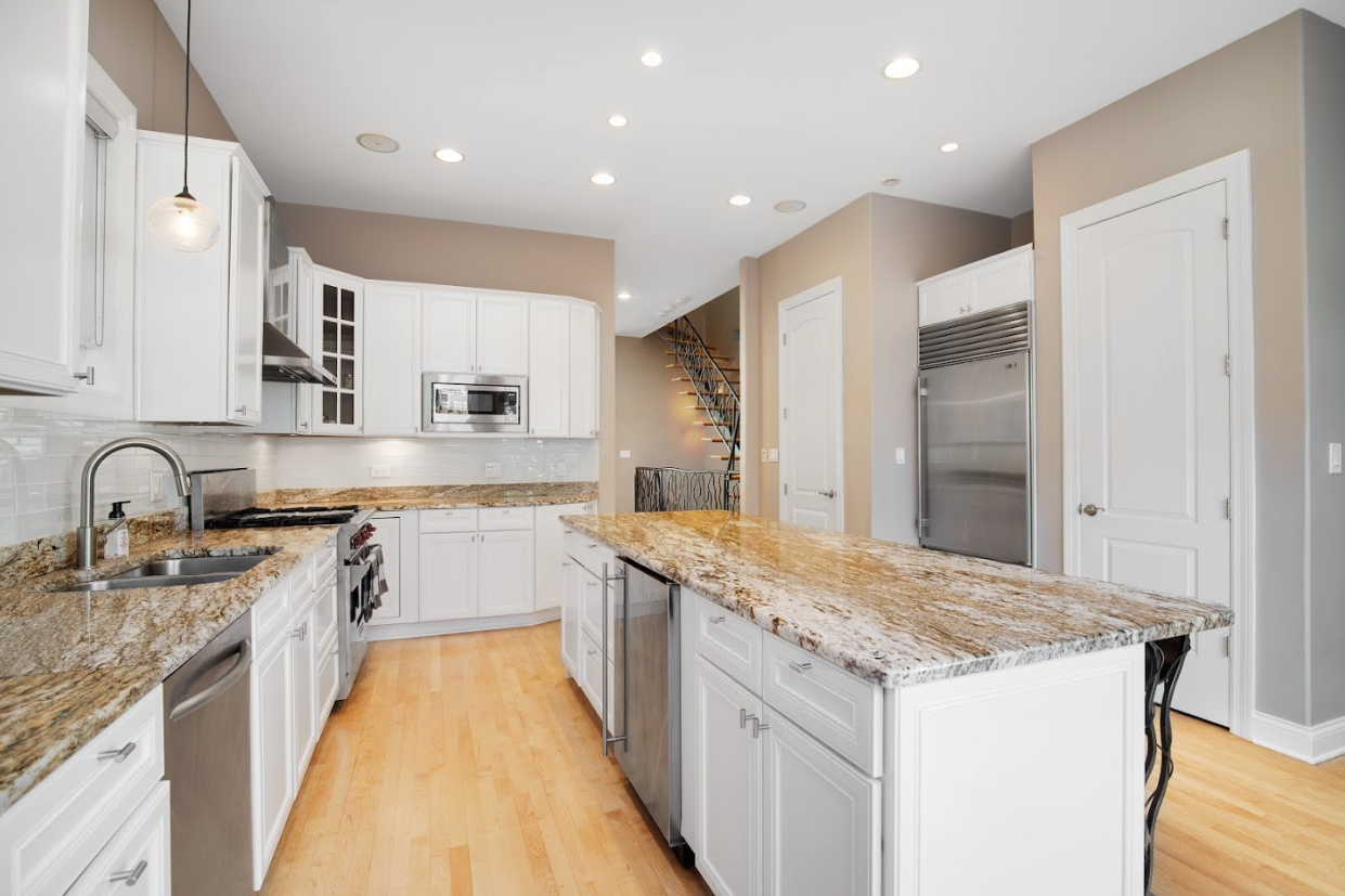 Bright white kitchen with granite countertops and island